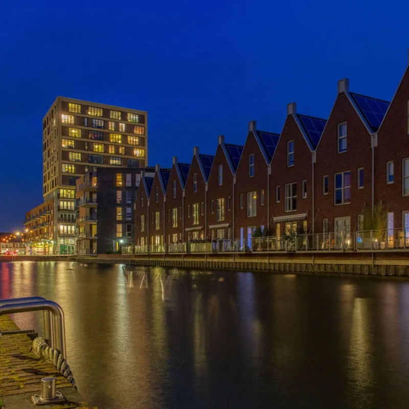 Website laten maken in Heerhugowaard Moderne bebouwing aan het water in Heerhugowaard bij avond, regio waar SjopSjop websites bouwt
